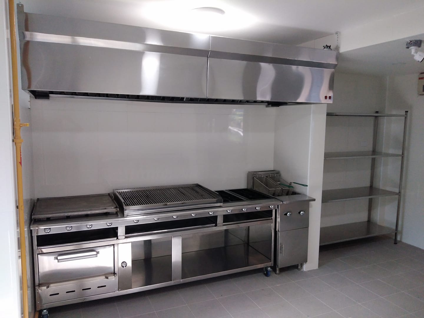 Cocina industrial de acero inoxidable con plancha y quemadores